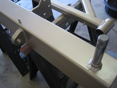 1996 Ford Bronco - A close-up view of a painted metal frame part, possibly a bumper component, resting on sawhorses.