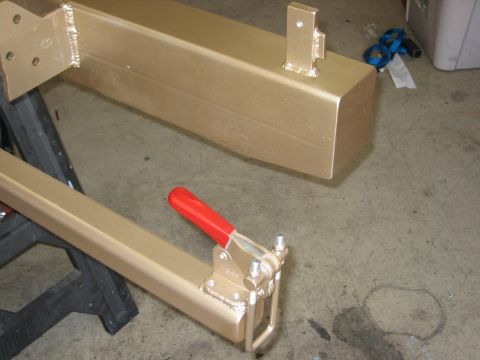 1996 Ford Bronco - Custom metal parts painted gold, one a toggle clamp, are shown in a workshop setting.