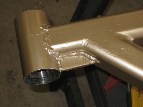 1996 Ford Bronco - Close-up view of a gold-painted metal component, likely a custom part, showing extensive welding.