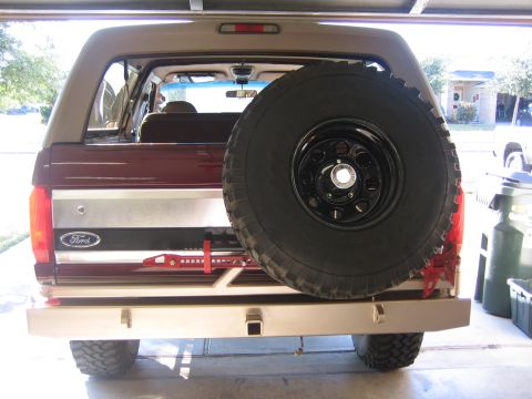 1996 Ford Bronco - Rear view of a maroon and tan Ford Bronco, equipped with a spare tire and an aftermarket bumper.