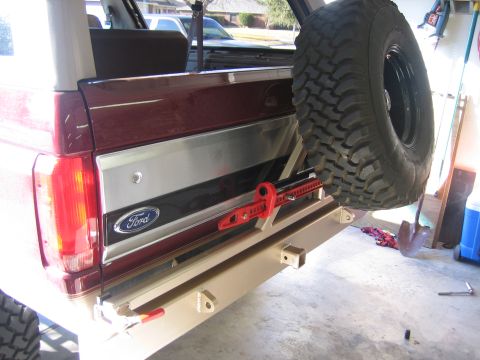 1996 Ford Bronco - The rear of a 1996 Ford Bronco shows a custom bumper with a spare tire carrier and a hi-lift jack attached.