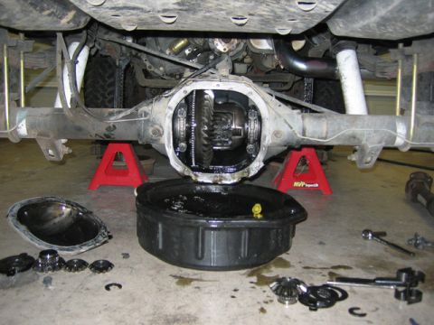 1996 Ford Bronco - The rear differential is disassembled for maintenance, with various gears and tools laid out on the concrete floor.