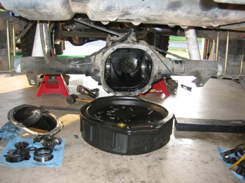 1996 Ford Bronco - Differential removed for service, showing gears and oil drain pan.