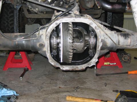 1996 Ford Bronco - Close-up view of an open differential housing supported by jack stands, with tools on the floor.