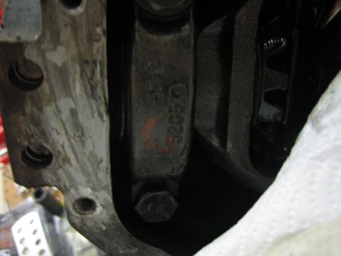 1996 Ford Bronco - A close-up view of a stamped engine component, showing part numbers and some red markings.