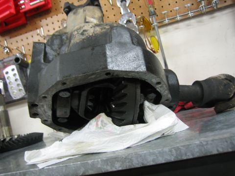 1996 Ford Bronco - A disassembled differential assembly is shown on a workbench, with internal gears exposed.
