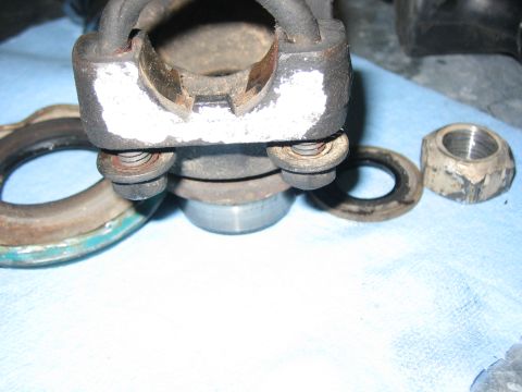 1996 Ford Bronco - Disassembled brake caliper components and a lug nut are laid out on a blue cloth for inspection or repair.