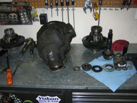 1996 Ford Bronco - Various differential components are spread across a workbench, ready for installation or repair.