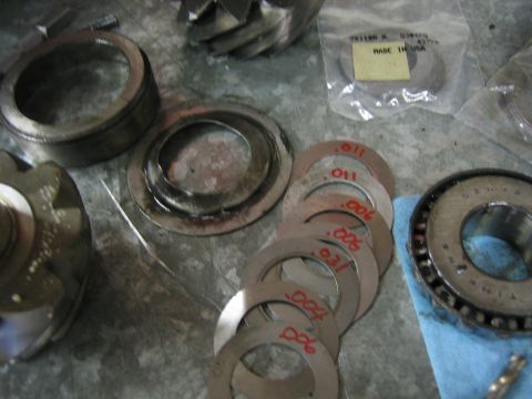 1996 Ford Bronco - Differential gears and shims are laid out on a workbench, ready for installation.