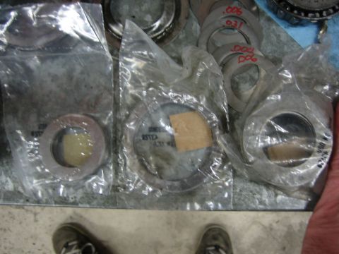 1996 Ford Bronco - Various differential shims are laid out, some in packaging, with measurements marked in red.