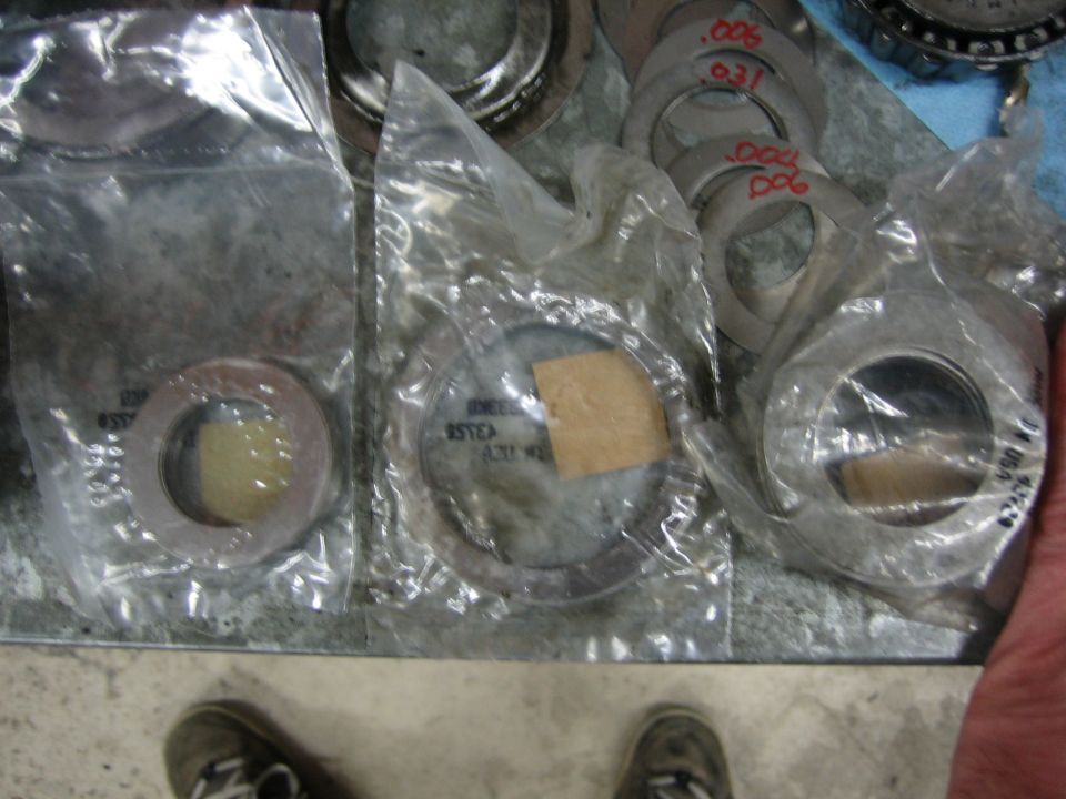 Differential shims in plastic bags and loose, some with red markings like .006 and .031