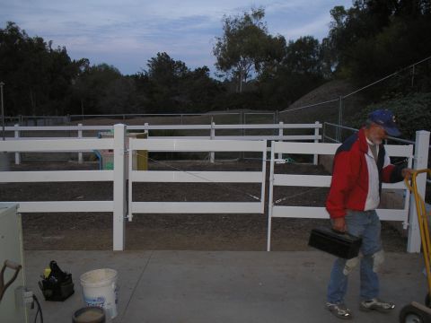1990 Ford Bronco - Man with toolbox near white fence and a yellow cart.