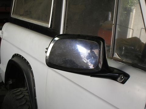 1966 Ford Bronco - A white 1966 Ford Bronco is shown from the side, highlighting its chrome side mirror and fender flare.
