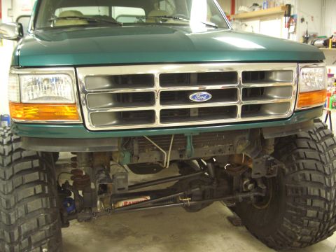 1996 Ford Bronco - Front view of a green 1996 Ford Bronco, highlighting its chrome grille and lifted suspension with oversized tires.