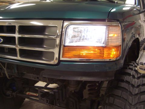 1996 Ford Bronco - Front view of a green Ford Bronco, showing its grille and headlight assembly with chrome accents.
