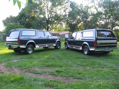 1995 Ford C-350 (Centurion Conversions) - Two dark green Ford C-350 Centurion Conversions SUVs are parked side-by-side on a grassy lawn.
