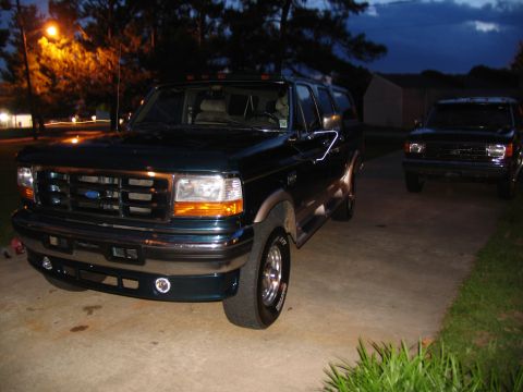 1995 Ford C-350 (Centurion Conversions) - A dark green 1995 Ford C-350 Centurion Conversions SUV is parked in a driveway at dusk, with another vehicle visible in the background.