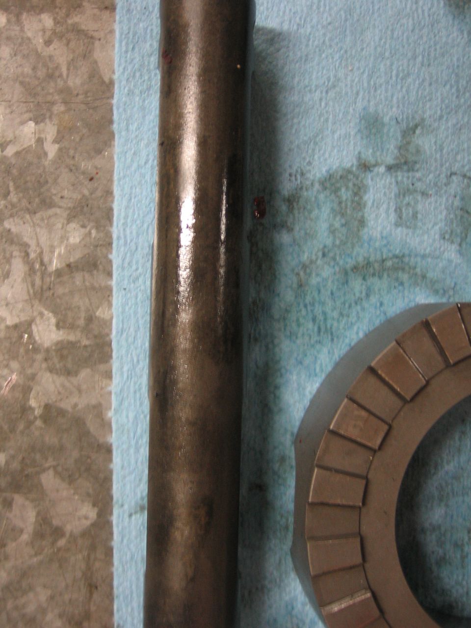 Metal shaft and gear part on blue shop towel