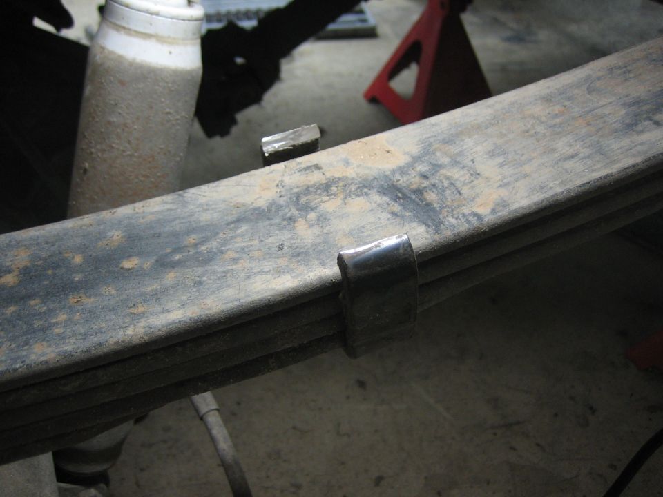 Leaf spring with U-bolt and shock absorber in garage