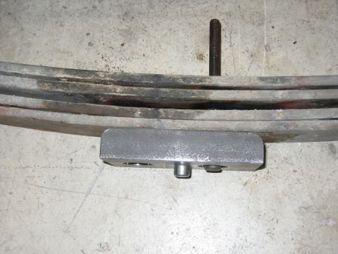 1996 Ford Bronco - Close-up of a vehicle's leaf spring assembly, showing a U-bolt and mounting bracket.