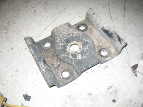 1996 Ford Bronco - A single, weathered metal bracket with visible rust and dirt is shown from a top-down perspective on a floor.