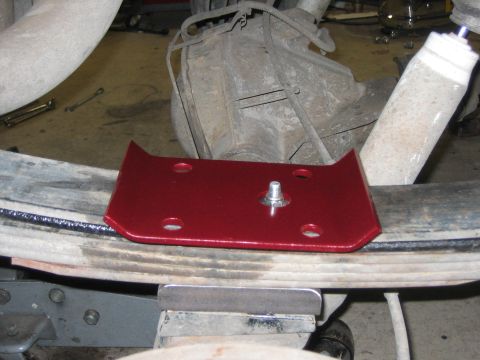 1996 Ford Bronco - Close-up of a red suspension component installed on a leaf spring assembly.