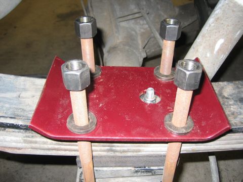 1996 Ford Bronco - Close-up of a vehicle's rear suspension leaf spring U-bolt plate and hardware.