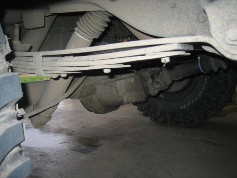 1996 Ford Bronco - Rear axle assembly with leaf springs and shock absorber visible, tire shows BFGoodrich branding.