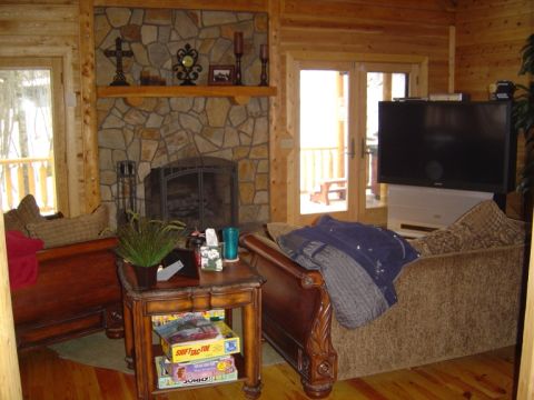 1986 Ford Bronco - A cozy log cabin interior features a large stone fireplace, a television, and comfortable seating, suggesting a relaxing getaway.