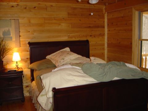 1986 Ford Bronco - Interior view of a bedroom wood-paneled walls and a large bed.