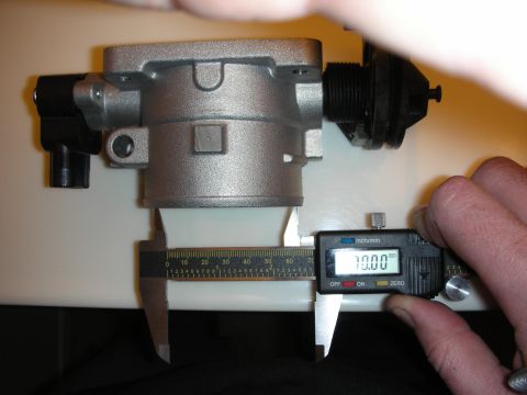 1998 Ford Crown Victoria - silver aluminum throttle body is held against a ruler while a digital caliper displays a 70.00 mm measurement.