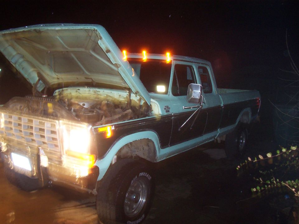 Ford F-Series truck with hood open at night. It has amber cab lights