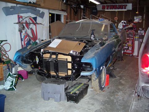 1971 Ford Ranchero - A blue 1971 Ford Ranchero is parked in a garage with its hood open, showing the engine bay and front grille area.