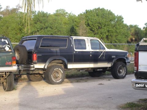 1993 Ford C-350 (Centurion Conversions) - Ford C-350 Centurion Conversion van parked next to a Jeep, with trees in the background.