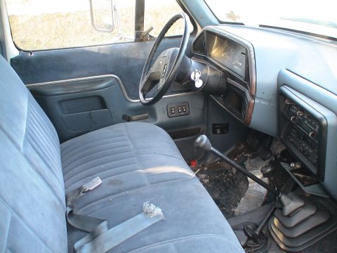 1993 Ford C-350 (Centurion Conversions) - The interior of a blue 1992 Ford F-Series truck, a bench seat and manual transmission.