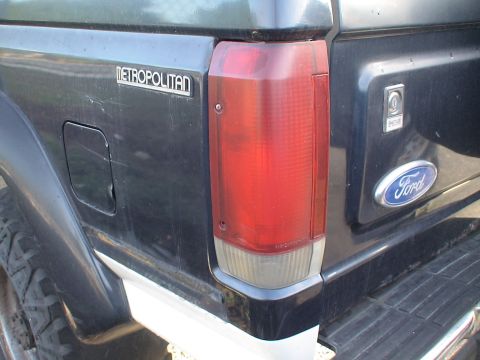 1993 Ford C-350 (Centurion Conversions) - Close-up of the rear of a dark pickup truck, a "METROPOLITAN" badge and a Ford emblem on the tailgate.