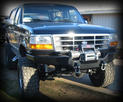 1996 Ford Bronco - This black Ford Bronco features a custom front bumper with a winch, indicating a model year around 1992.