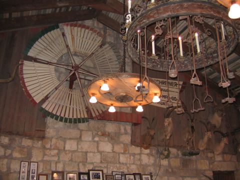 1996 Ford Bronco - A rustic interior features two large chandeliers, one adorned with cattle brands, and a decorative windmill above taxidermied animals.
