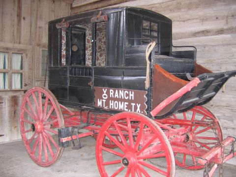 1996 Ford Bronco - This stagecoach, marked Y Ranch Mt. Home, TX, is displayed indoors with wooden walls.