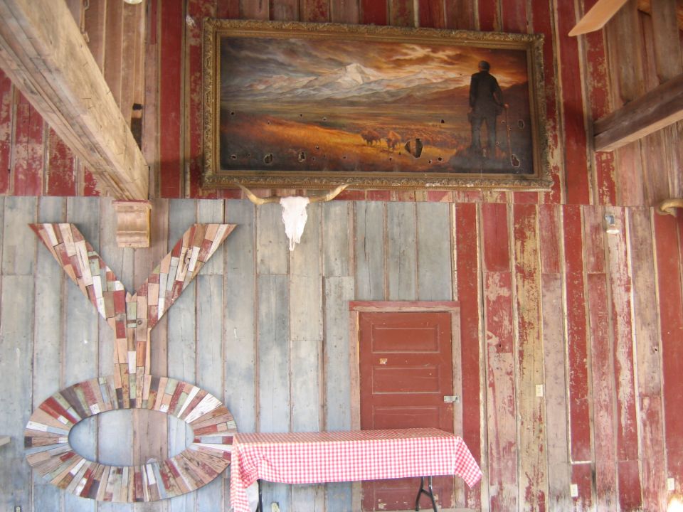 Room with a painting of a man and bison, a longhorn skull, and large 'YO' letters