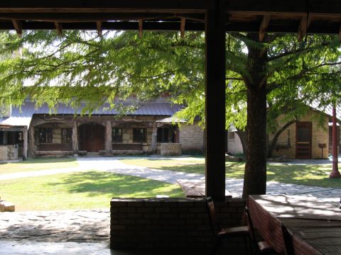 1996 Ford Bronco - A view of a rustic building and its grounds, framed by trees and a covered patio.