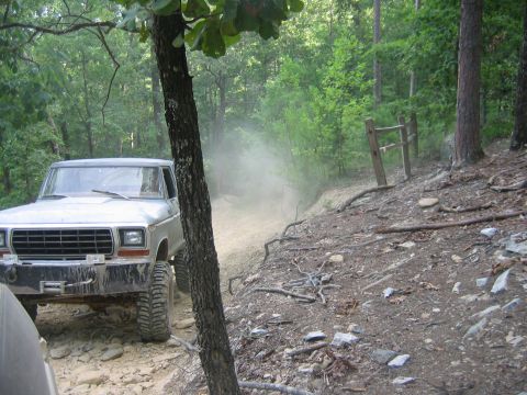 1992 Ford Mustang - A Ford F-Series truck navigates a dusty off-road trail through a wooded area.