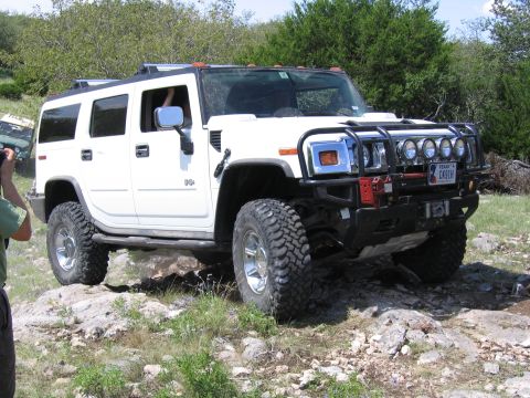 1996 Ford Bronco - A white Hummer H2 navigates a rocky trail, its off-road capabilities.
