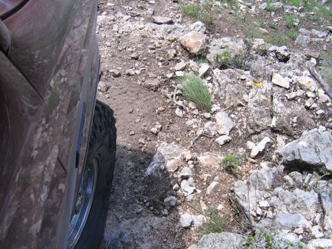 1996 Ford Bronco - The vehicle is navigating a rough, rocky terrain with sparse vegetation.