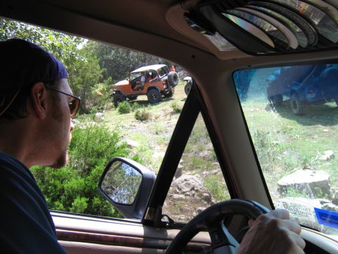 1996 Ford Bronco - Two off-road vehicles navigate a rocky trail on a sunny day.