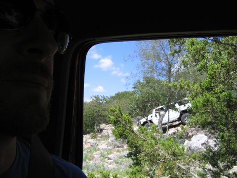 1996 Ford Bronco - White SUV navigating a challenging off-road course under a blue sky.