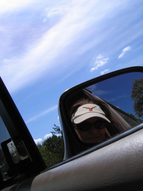 1996 Ford Bronco - Driver's reflection visible in the side mirror, wearing a visor with the Texas Longhorns logo.