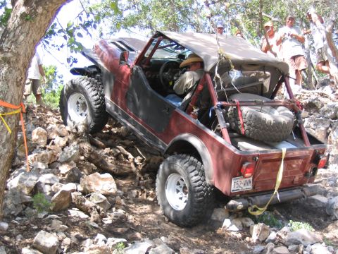 1996 Ford Bronco - Off-road vehicle tackling a challenging rocky terrain, with spectators watching.
