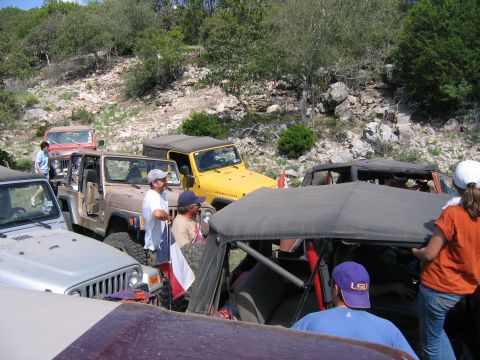 1996 Ford Bronco - A group of Jeep Wranglers are gathered on a rough, outdoor terrain.