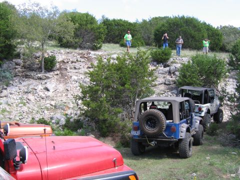 1996 Ford Bronco - Jeeps gathered on a rocky trail with onlookers observing the scene.